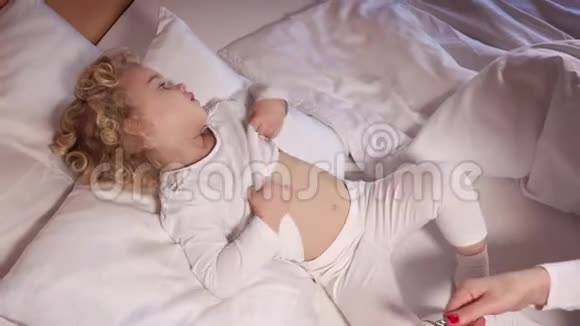 儿科医生检查小可爱的女孩躺在床上用听诊器视频的预览图