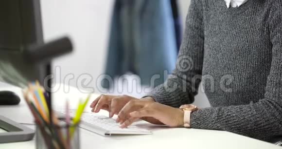 年轻女子在办公室的电脑上打字视频的预览图