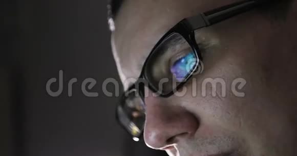 一个戴着眼镜的年轻人在黑暗中的脸视频的预览图
