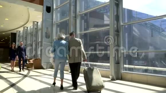两个年长的人带着手提箱走路视频的预览图