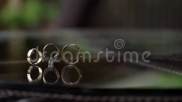 玻璃桌上有钻石卷的结婚金戒指视频的预览图