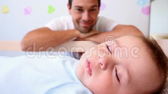 快乐的父亲照看婴儿床视频的预览图