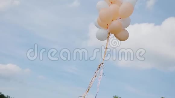一束白色和米色的球飞向天空美丽的天空和云彩视频的预览图