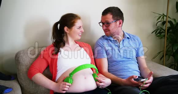 孕妇在与男性互动时戴上耳机视频的预览图