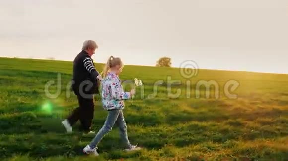 祖母和孙女正在乡间散步他们在日落时沿着乡间小路走活动视频的预览图