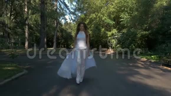 一个穿着白色西装的漂亮女人走得很快在城市公园里跑步视频的预览图