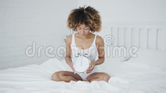 带钟的女人在床上摆姿势视频的预览图