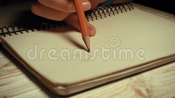 女孩用铅笔在笔记本上画素描视频的预览图