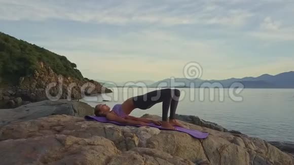 Flycam图片展示了一位在海洋山丘上摆出瑜伽姿势的女孩视频的预览图