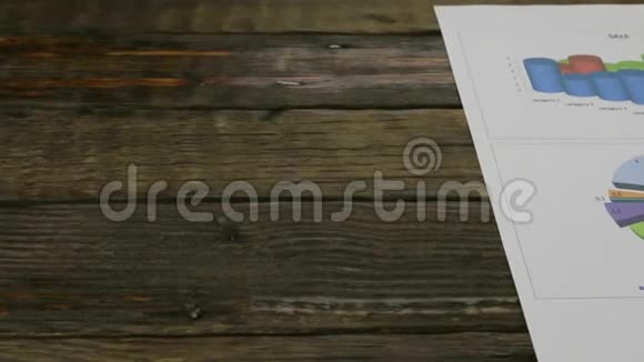一张木桌上放着图表的纸滑块摄像机的运动视频的预览图