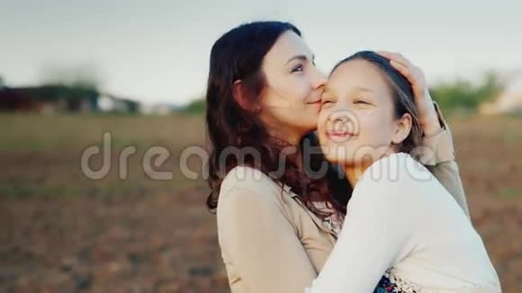 妈妈温柔地拥抱了她的女儿11年他们一起朝一个方向看夕阳家庭价值观视频的预览图