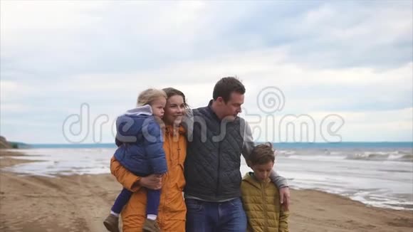快乐而友好的家庭在休息日和孩子们一起在海滩散步视频的预览图