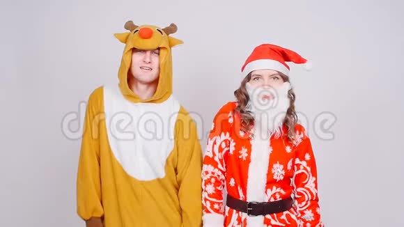 年轻女子戴着圣诞帽男子穿着鹿的狂欢节服装欢乐节日和圣诞节视频的预览图