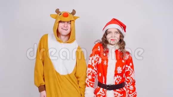 年轻女子戴着圣诞帽男子穿着鹿的狂欢节服装欢乐节日和圣诞节视频的预览图