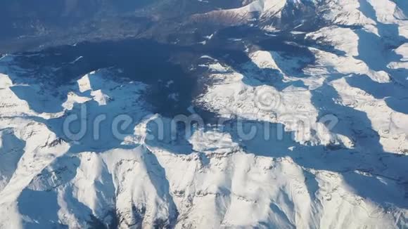 在冬季日落时飞越阿尔卑斯山从飞机窗口可以看到空中景色视频的预览图