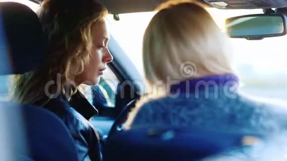 两个女人在车里交流笑笑乐碑后视图视频的预览图