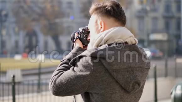 英俊的年轻男性摄影师在室外拍照视频的预览图