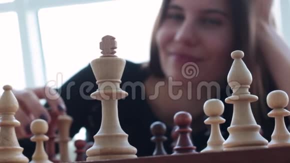 一位美丽的年轻黑发拉丁女人在家下棋时露出一个迷人的牙齿微笑视频的预览图
