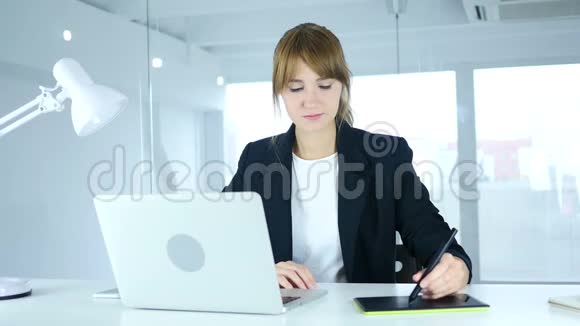 年轻的女设计师正在为电脑绘制平板电脑视频的预览图