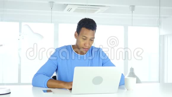 年轻的非裔美国人在办公室里伸展和放松身体视频的预览图