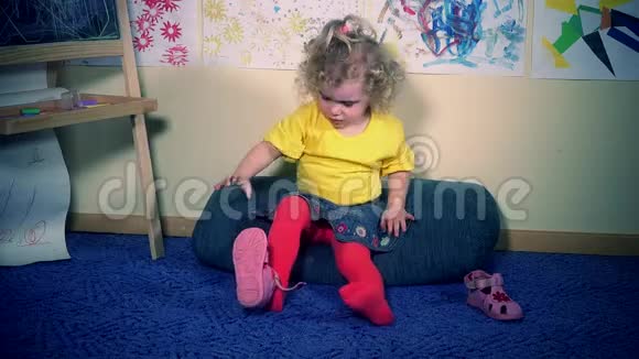 沮丧的小女孩穿上自己的凉鞋视频的预览图