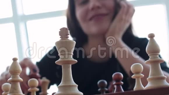 一位美丽的年轻的黑发拉丁女人在家下棋时带着迷人的牙齿微笑视频的预览图