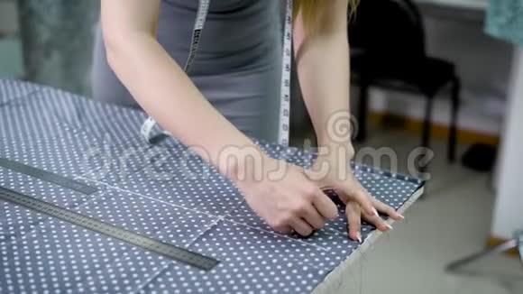 年轻女性裁缝用粉笔在圆点组织上绘制图案视频的预览图