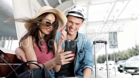 旅行夫妇使用电话在机场附近等候交通视频的预览图