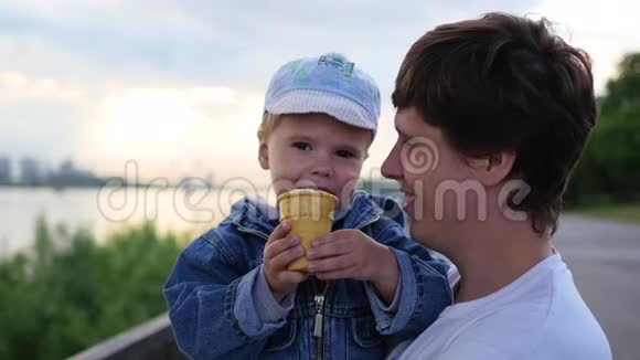 一个孩子和他父亲在公园里近距离地吃一个华夫饼里的冰淇淋视频的预览图