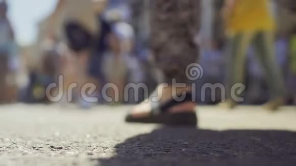 在阳光明媚的街道上行走的人腿模糊视频的预览图
