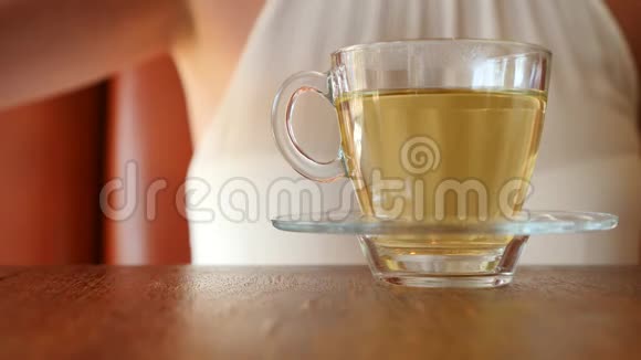 女孩把一块红糖放在一个透明的杯子里上面有绿茶气泡上升4K慢动作视频的预览图