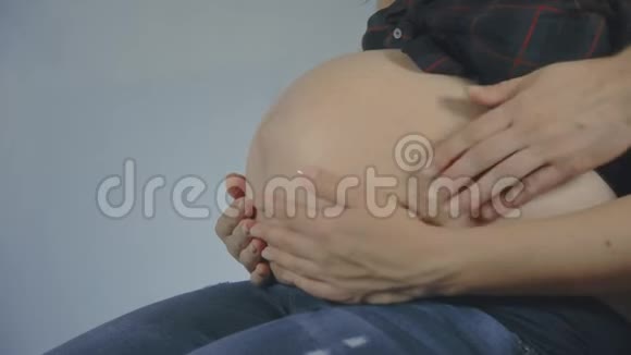 爸爸妈妈把手放在怀孕的肚子上怀孕夫妇抚摸怀孕的肚子视频的预览图
