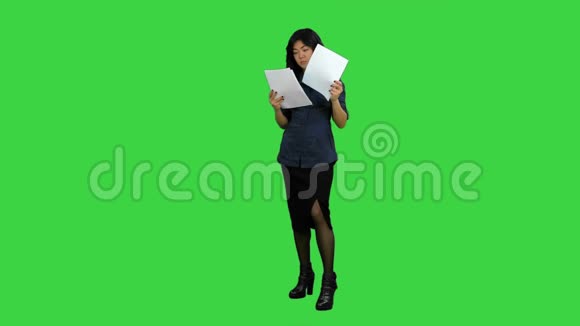 年轻的女商人拿着文件在绿色屏幕上阅读文件Chroma键视频的预览图