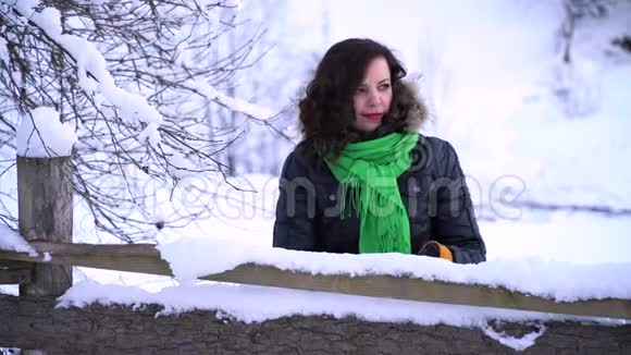 冬天森林里的年轻漂亮女孩女孩正看着白雪覆盖的树3她用手摸着雪白的树枝视频的预览图