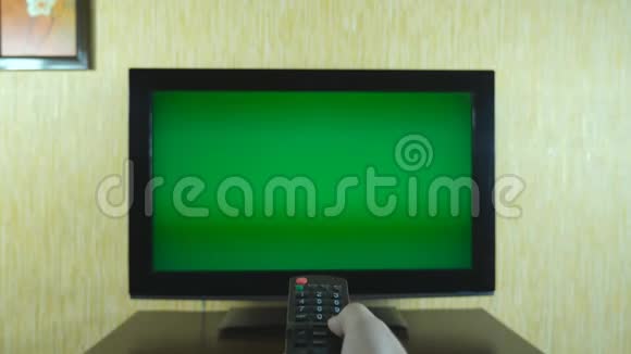 男性手使用遥控器在绿色屏幕电视上翻转频道男子冲浪电视频道视频的预览图