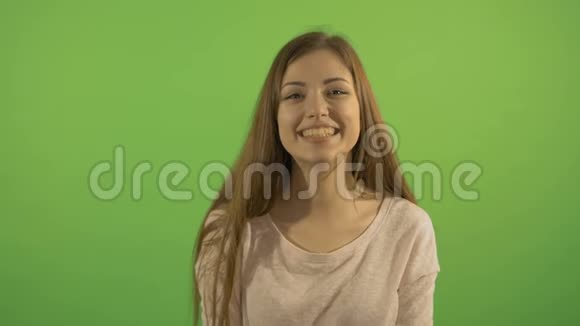 一个微笑和笑的漂亮女孩的肖像在绿色屏幕的背景上视频的预览图