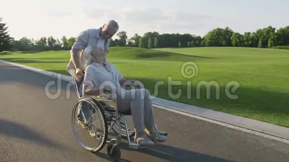 与妻子坐轮椅散步的老夫妇视频的预览图