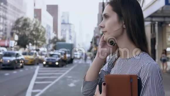 在美国纽约街头工作的年轻女商人女经理在市中心谈论智能手机视频的预览图
