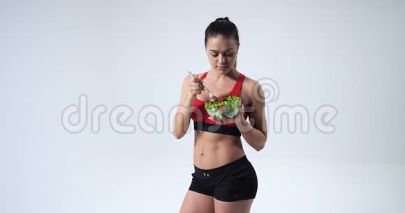 美丽的健身少女吃蔬菜沙拉和微笑健康的生活方式理念白色背景视频的预览图