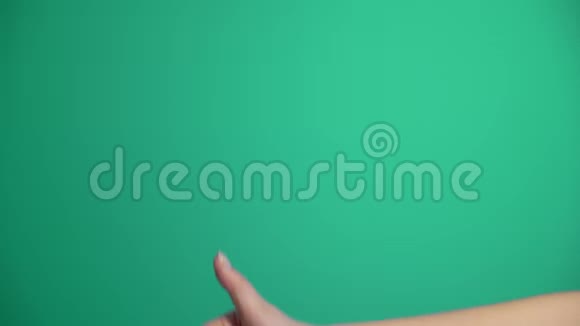 年轻开朗的白种人女人在绿色背景下竖起大拇指视频的预览图