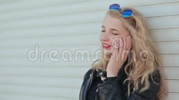 一个年轻漂亮的金发女郎穿着皮夹克戴着约翰列农风格的眼镜在一个视频的预览图