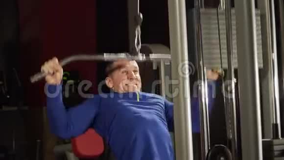 在健身房训练三头肌手那个人在健身房举重强壮的运动员重型列车视频的预览图