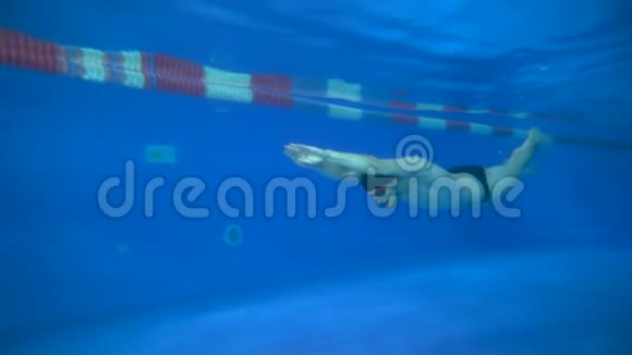 美丽的年轻游泳运动员只用脚爬行在水下游泳水下景观4K视频的预览图