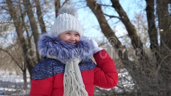 一个孩子在雪地里公园里玩冬天外面一个女婴的肖像动作缓慢视频的预览图