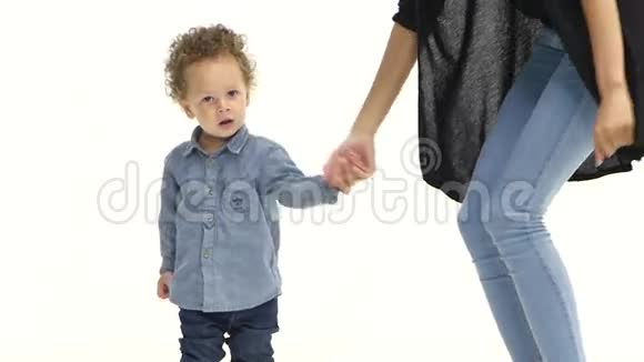 孩子握着母亲手和她跳舞白色背景慢动作视频的预览图