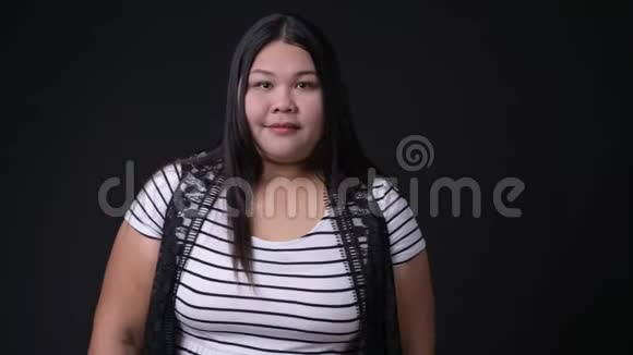 黑人背景下美丽的超重亚洲女人视频的预览图