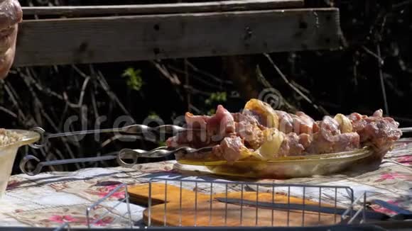 村里的户外桌上放着腌制的生烤肉的歪果仁视频的预览图