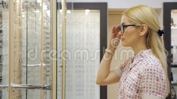 在眼镜店试新眼镜的快乐年轻女子视频的预览图