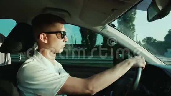 一个戴太阳镜的年轻人开车视频的预览图