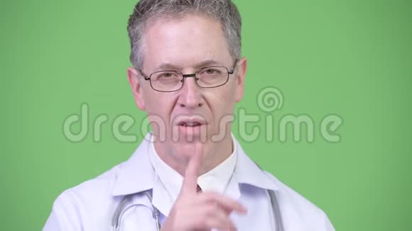 一副成熟的男医生的画像手指在嘴唇上视频的预览图